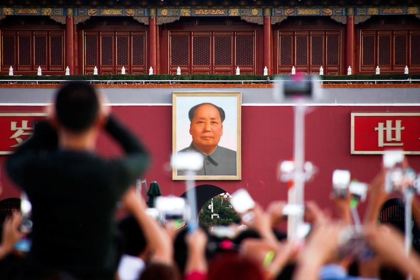 People take pictures during the flag raising ceremony on Tiananmen Square