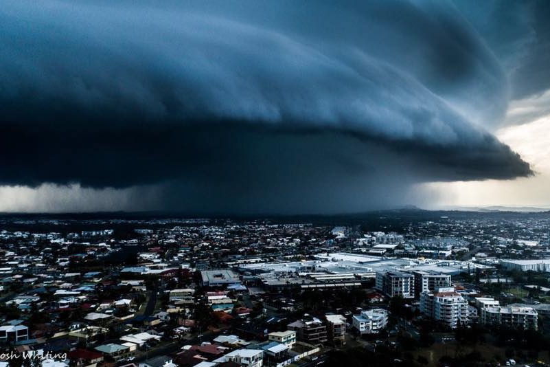 A very dark and large cloud hangs over a town
