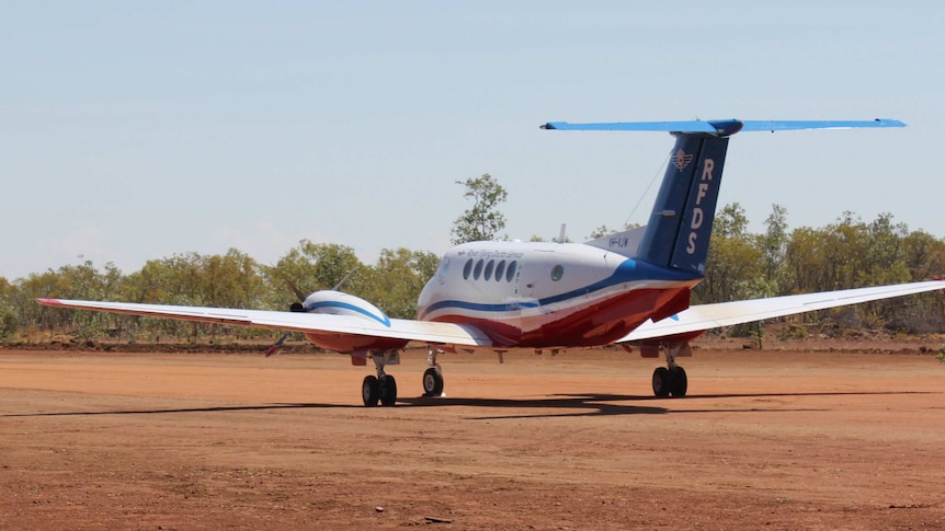 A Royal Flying Doctor Service plane lands on an airstrip.