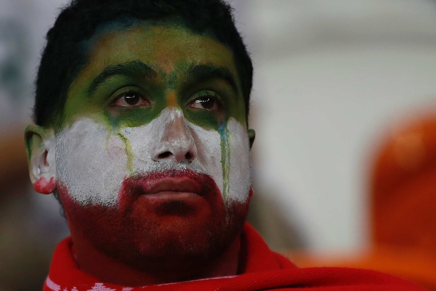 An Iranian fan with tears down his cheeks