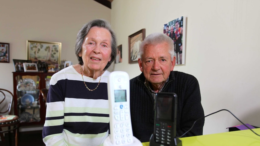 Joy and Don Baron at their home in Mentone, in Melbourne, with their landline telephone in the foreground.