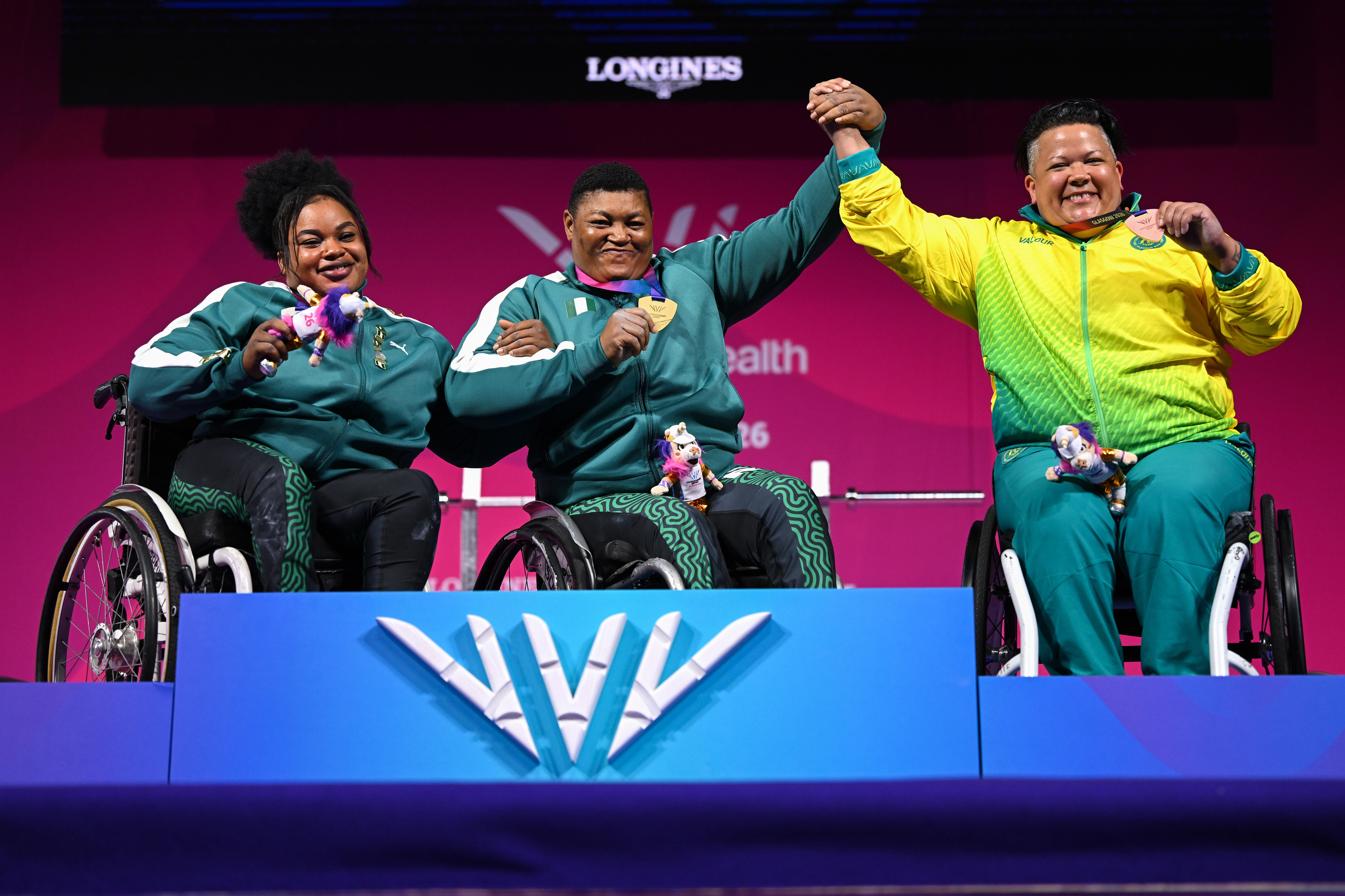 Powerlifters Rita Ferdinand, Folashade Oluwafemiayo and Hani Watson celebrate on the Glasgow Commonwealth Games podium.