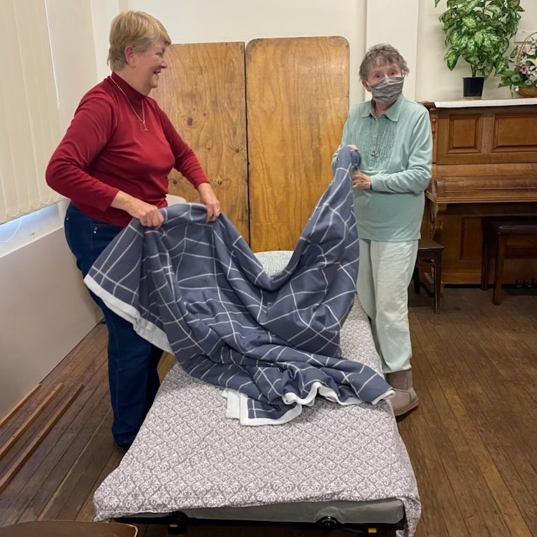two women making portable bed