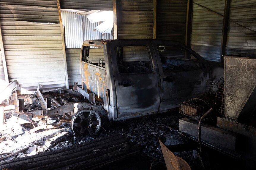 A burnt ute inside a shed damaged by fire