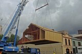 A replica of the Antarctic hut used by explorer Douglas Mawson is lowered into place near Hobart's waterfront.