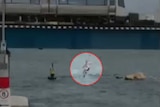 Grainy footage of a man jumping off the Fremantle train bridge into the water.