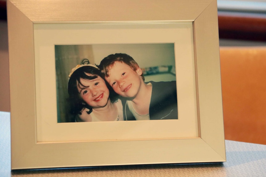 A photograph of a photo frame containing a picture of Beth Wright and her half-brother as children.