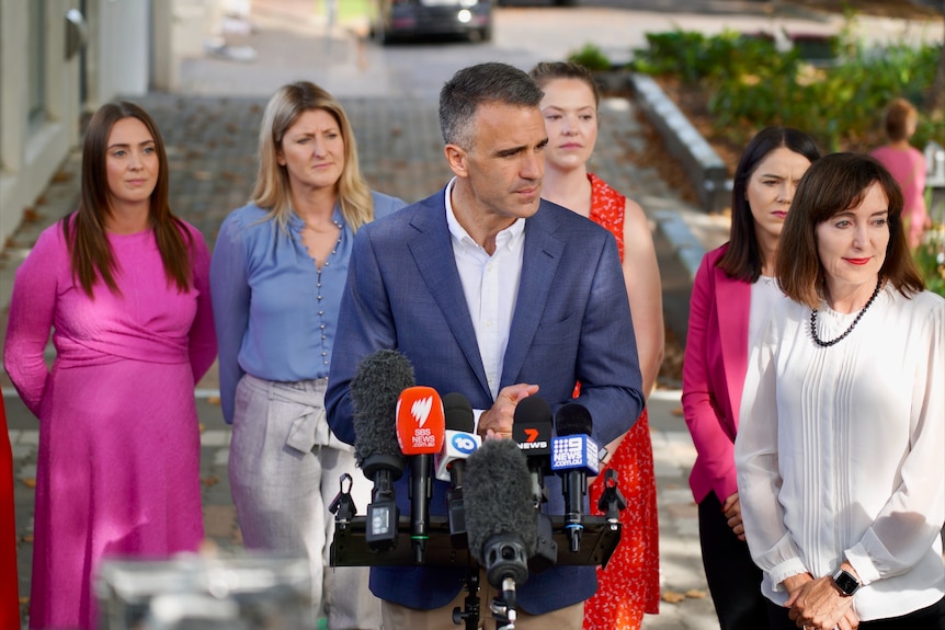 A man standing in front of five women