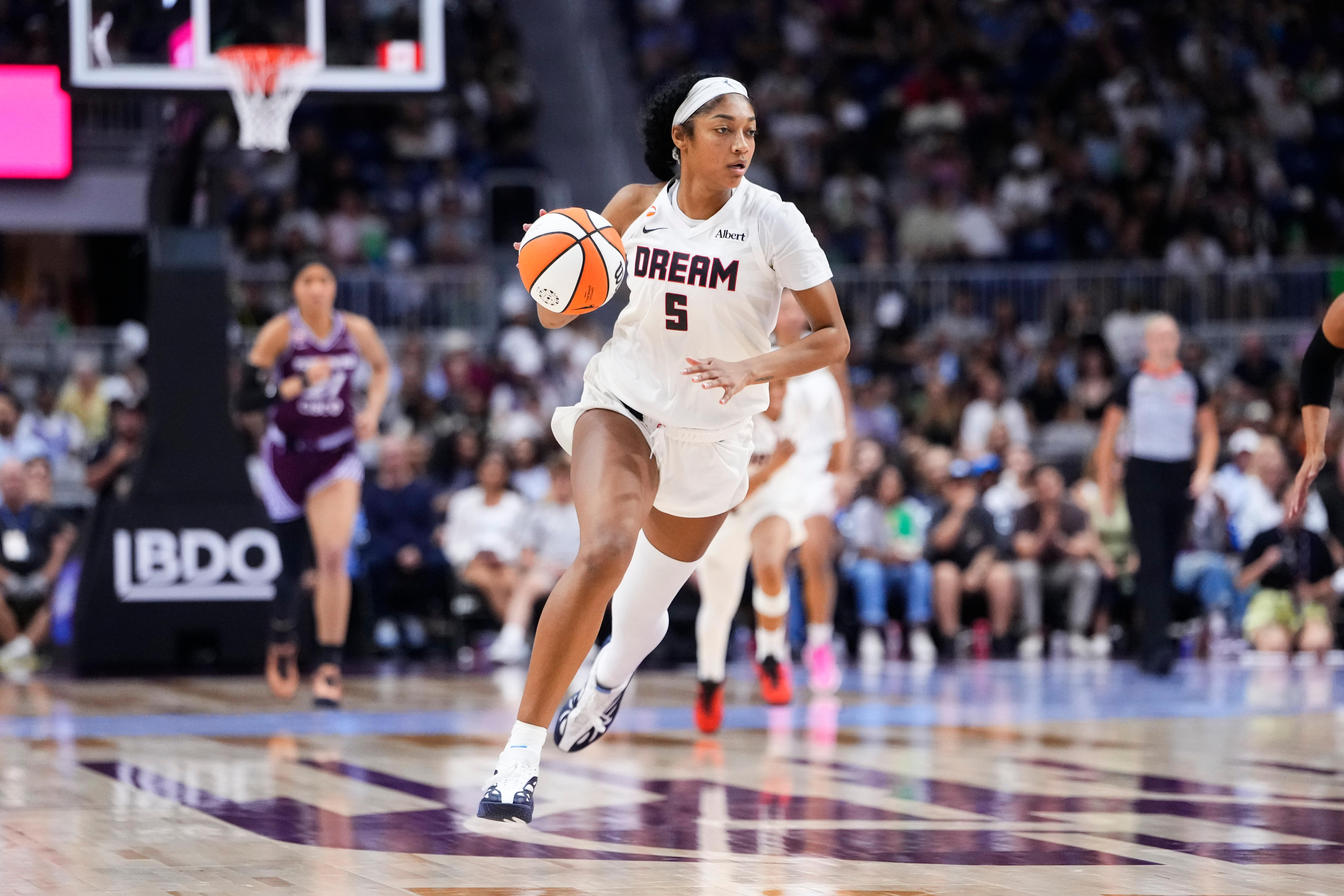 Angel Reese dribbles the ball for Atlanta Dream in a WNBA game.