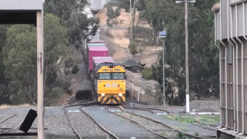 A freight train navigates a hill.