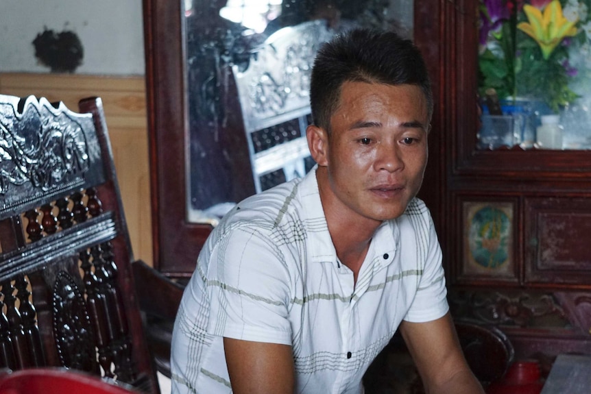 Vo Ngoc Chuyen sits in a chair and looks distressed