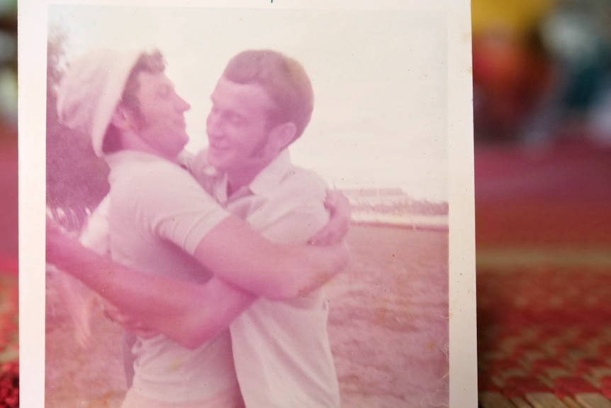a polaroid picture shows two men embracing