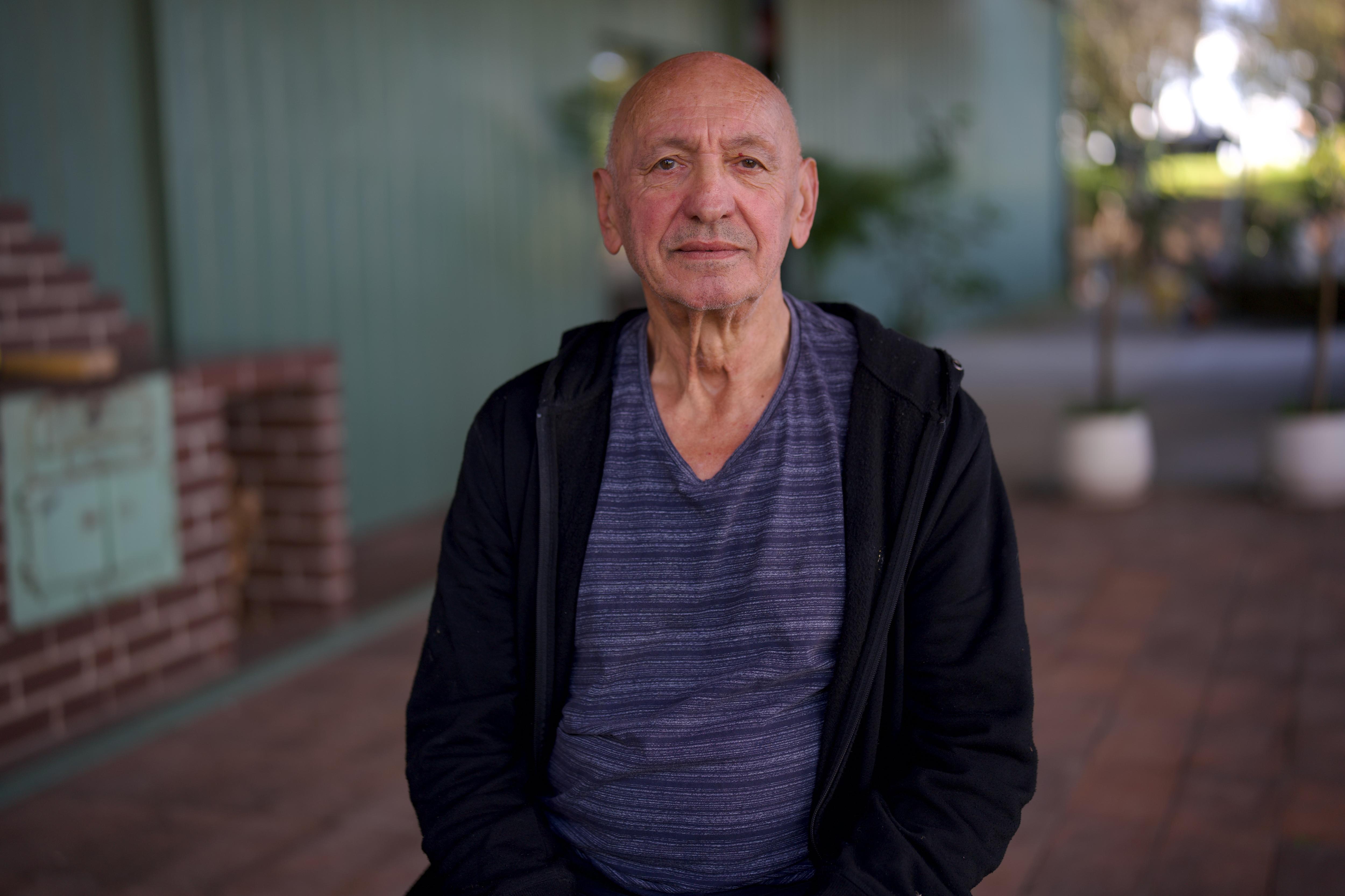 A man sitting on a chair outside.