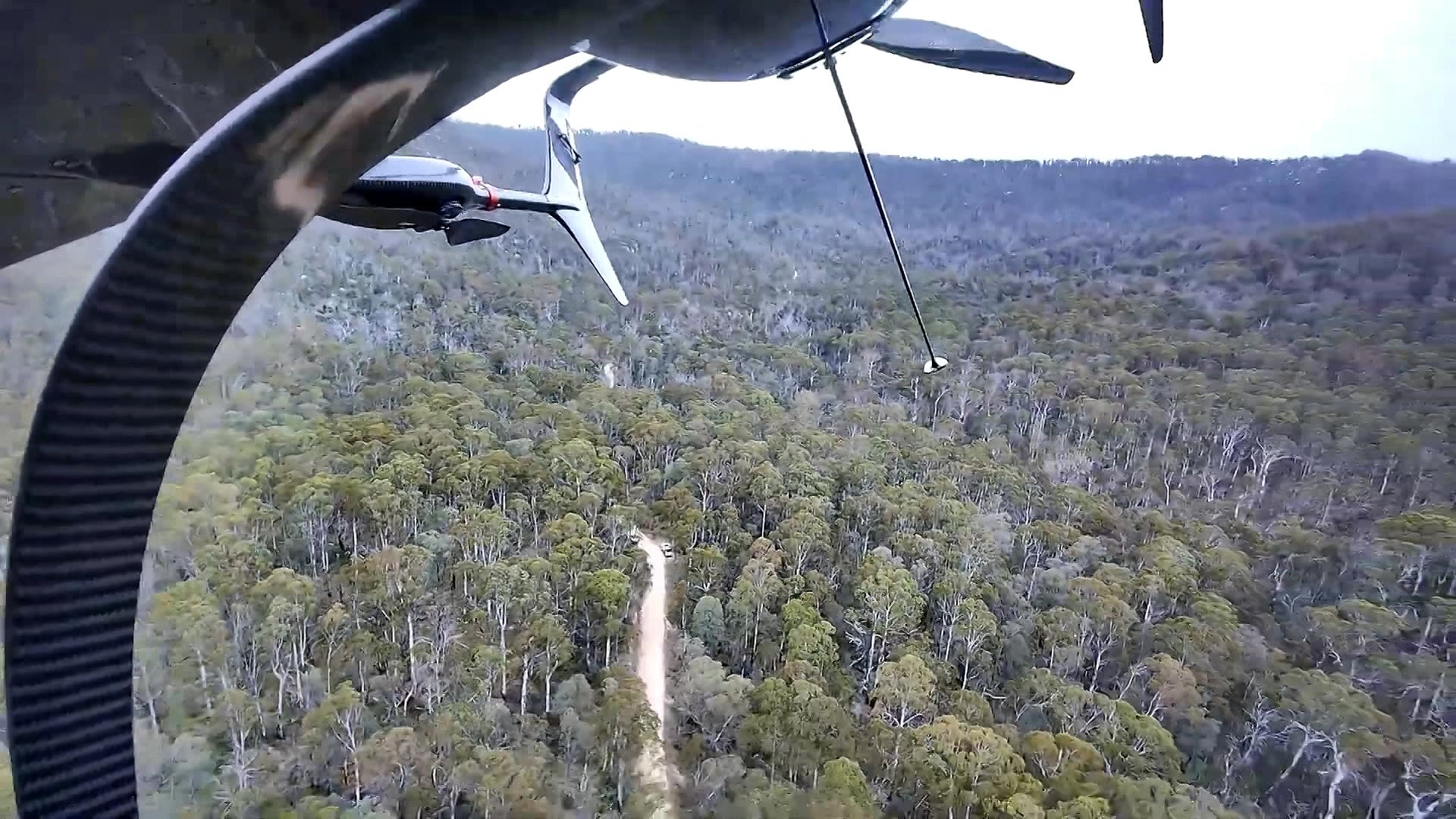 Underside of scout drone as it flies over dense bushland