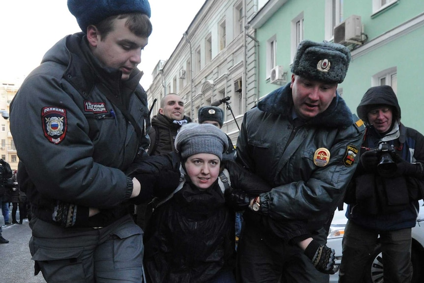 Police officers detain a gay rights activist in Moscow