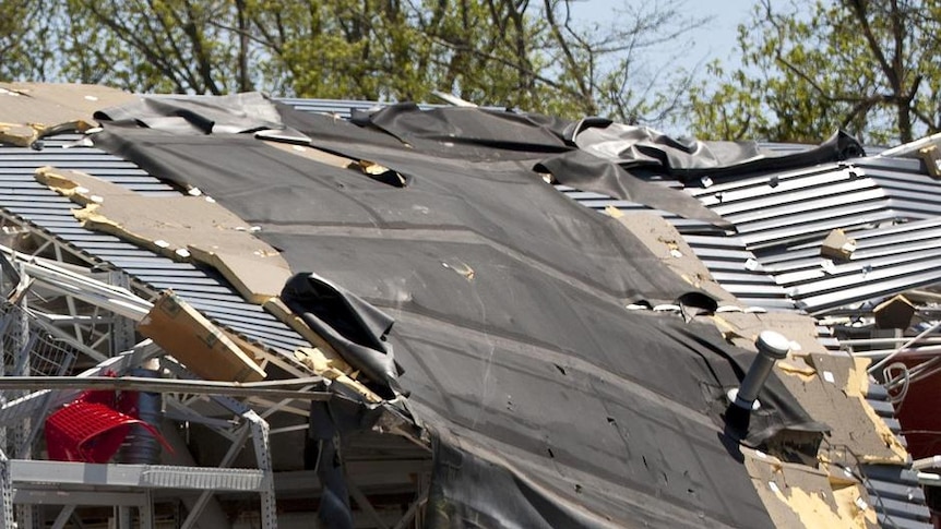 Workers survey the remains of a destroyed store after a tornado tore through Sanford