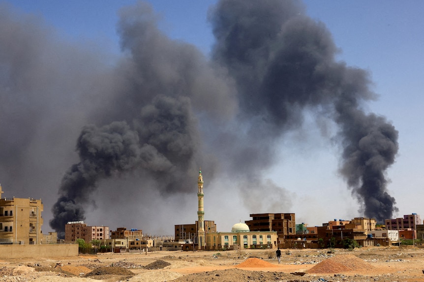 Smoke rising from two locations with mosque pictured in the middle