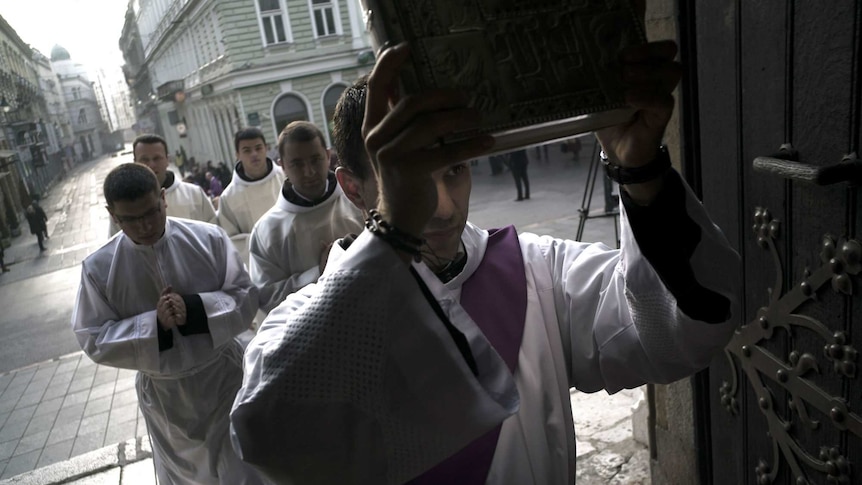 A priest leads an Advent procession into Sarajevo's Catholic Cathedral