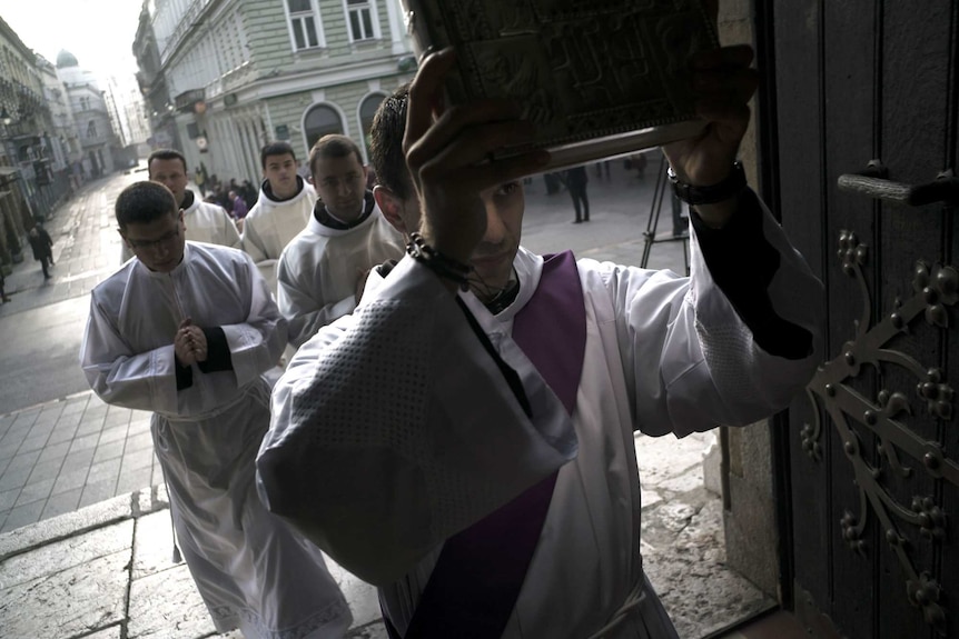 A priest leads an Advent procession into Sarajevo's Catholic Cathedral