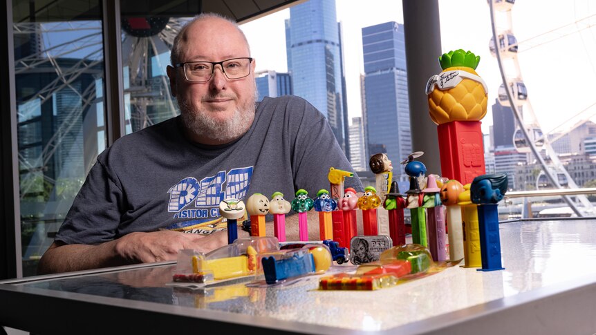 A man next to some colourful candy dispensers