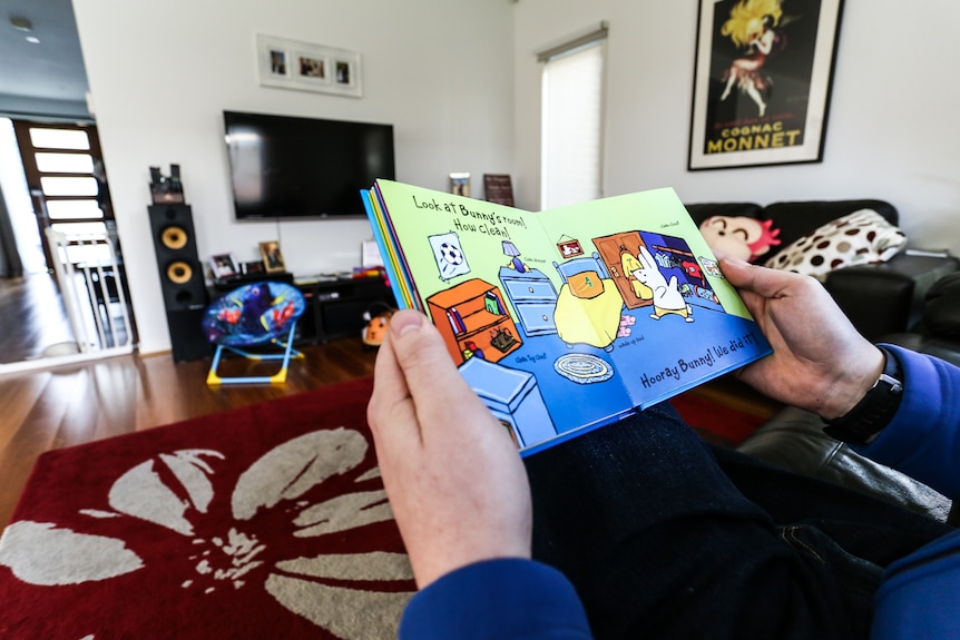 A close-up of Anthony reading his child's book.