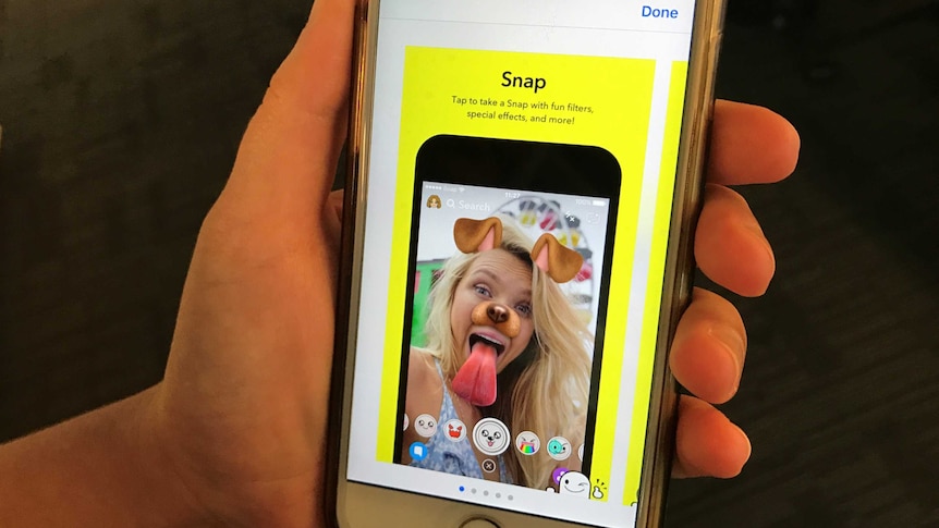 A person scrolls through their phone to download the Snapchat app