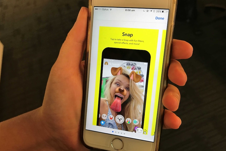 A person scrolls through their phone to download the Snapchat app