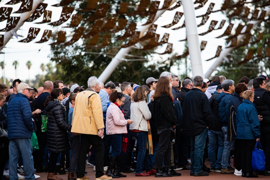 A crowd of people lining up at Perth Stadium.