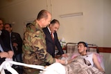 Syrian government officials visit a chemical attack victim
