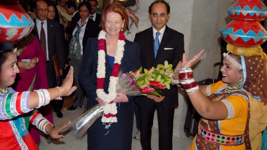 Gillard arrives at hotel in India to a traditional welcome.