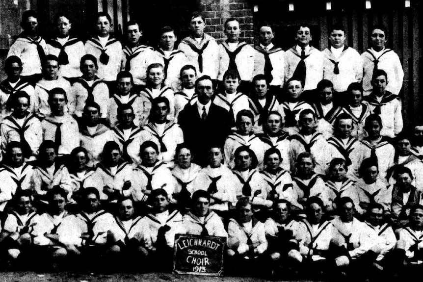 A back and white image of a large boy's choir in 1913, all dressed in uniform.