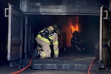 Firefighters sit inside a black box with flames in it