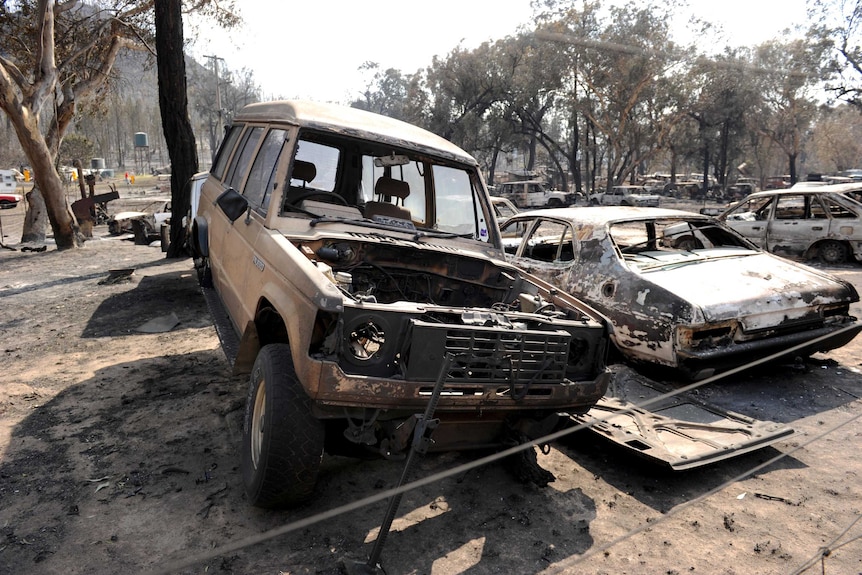 Burnt out car bodies at a property after bushfire swept through Coonabarabran.