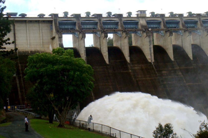 A man photographs water being released from Somerset Dam