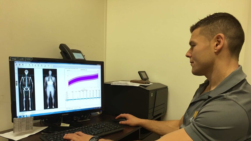 Sports scientist views data relating to study on a computer