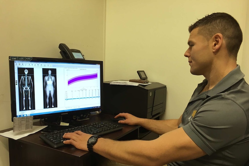 Sports scientist views data relating to study on a computer