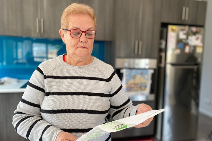 Wendy Fox reads her power bill in her kitchen. 