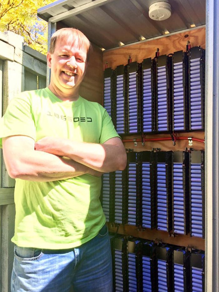 Pete Matthews stands in front of his homemade powerwall.