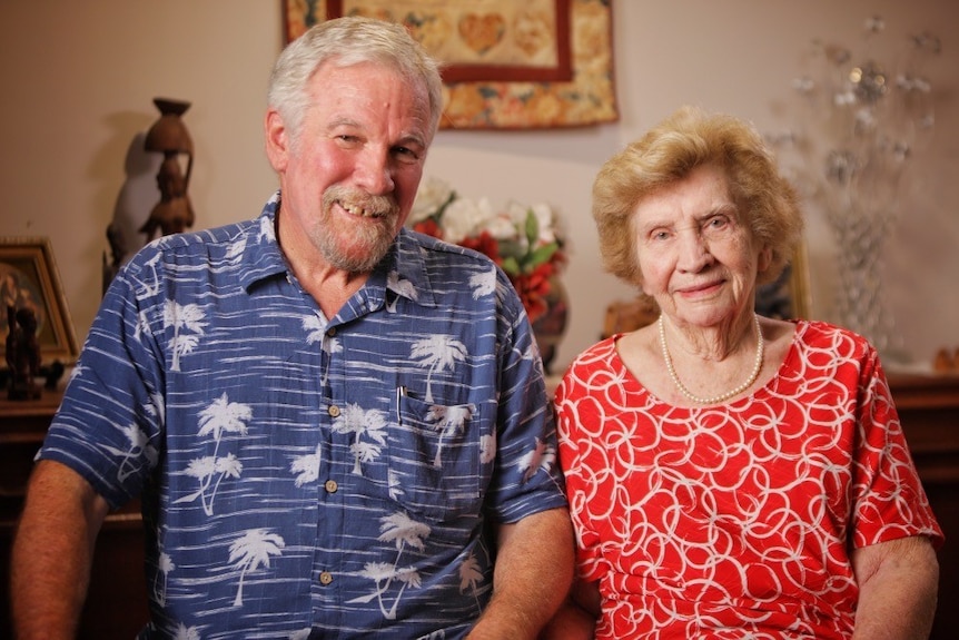 Son with elderly mother sitting at home.