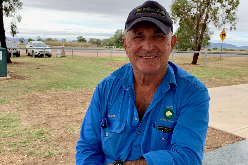 Farmer Graeme Noman sits in a blue shirt and cap.