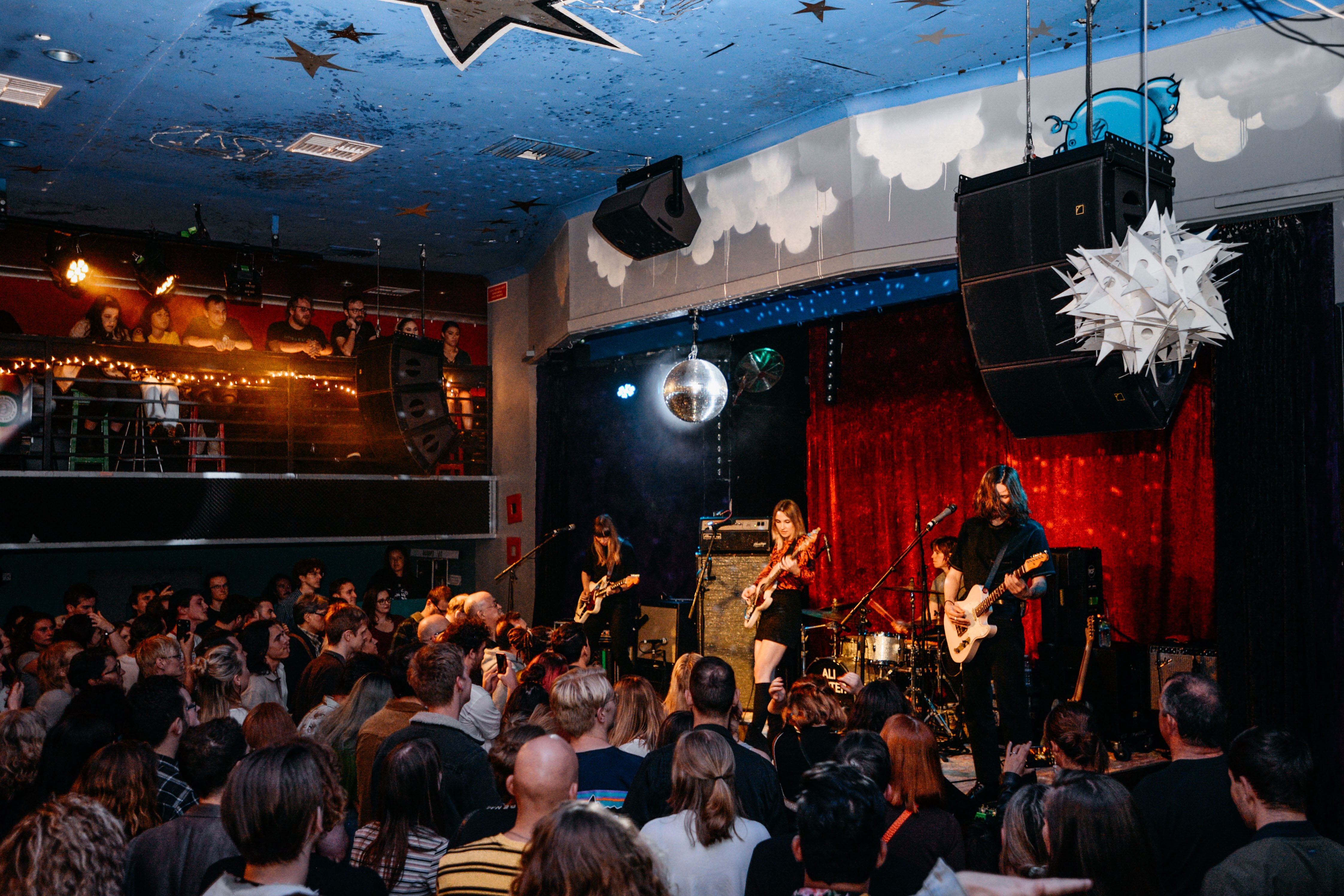 A band plays on stage and a crowd watches them