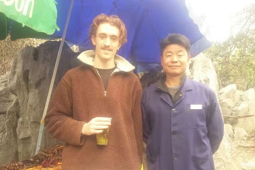 Chinese student Theo Stapleton stands with another man in this photo.