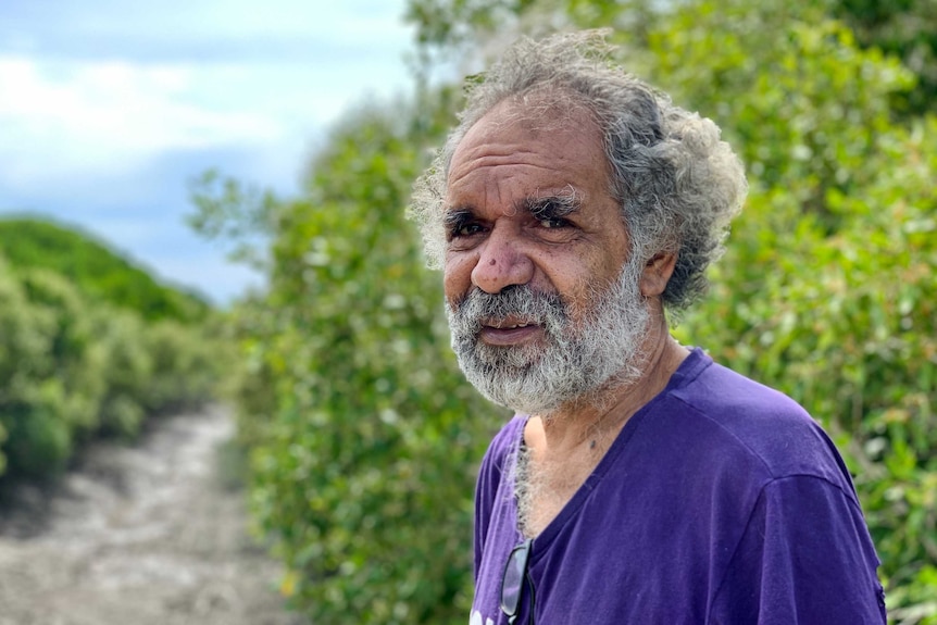 A man with greying hair stares at the camera