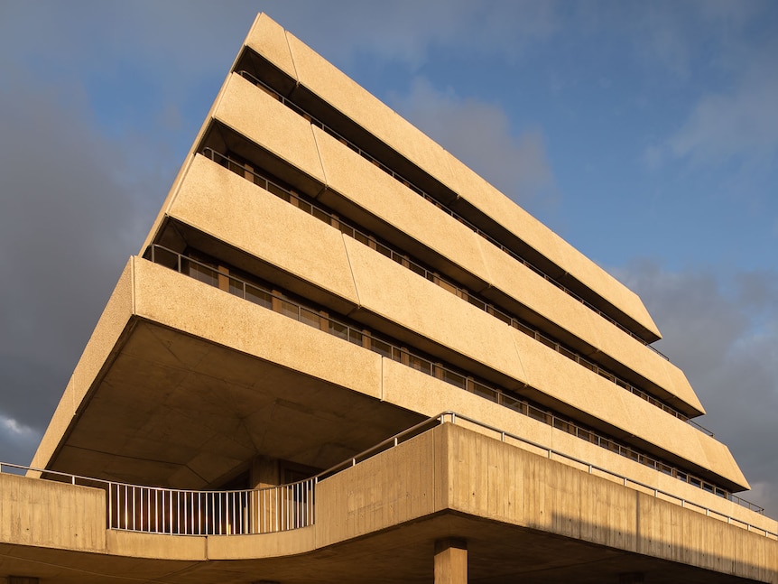 a brutal concrete building, shot from the ground looking up