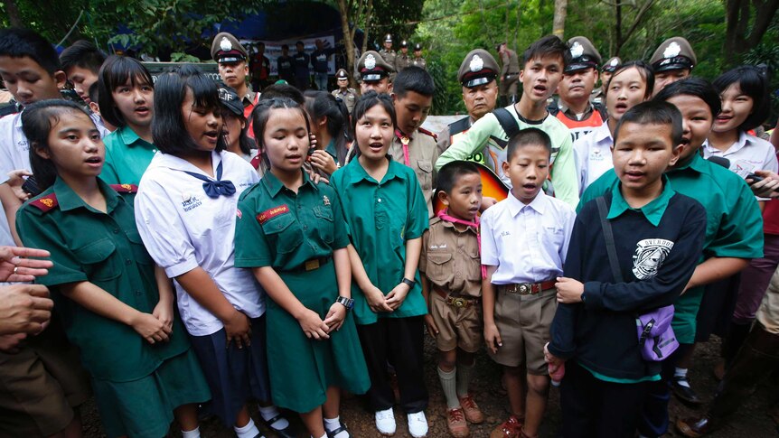 School friends of trapped Thai soccer team sing outside cave
