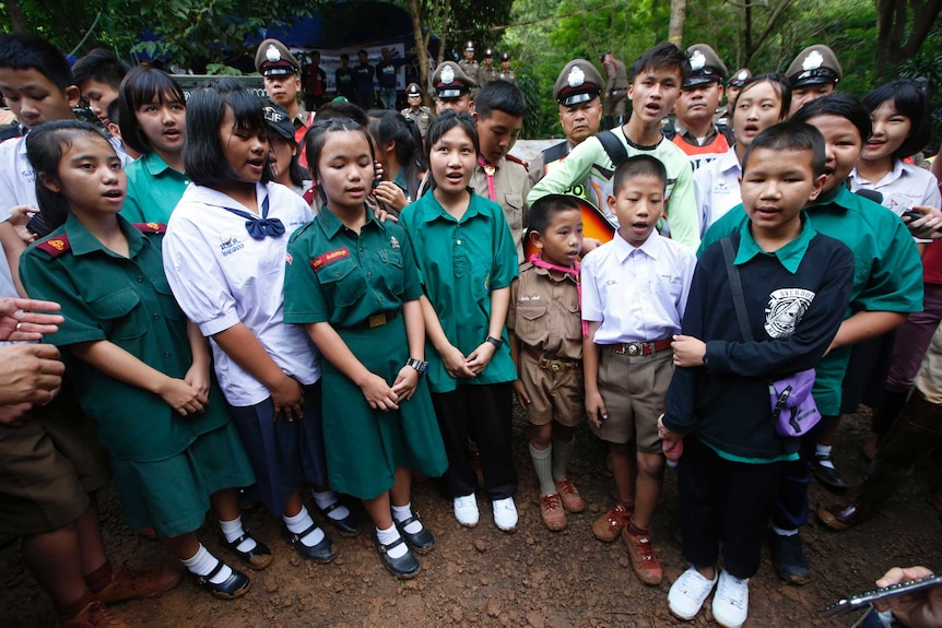 School friends of trapped Thai soccer team sing outside cave