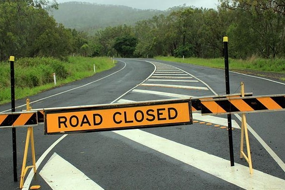 A sign and barrier marking a road closed