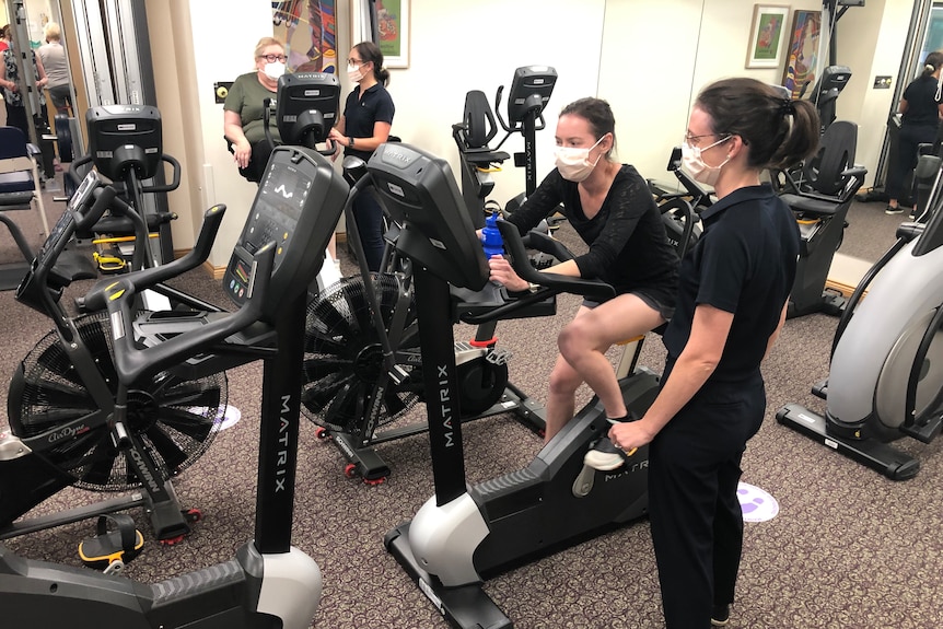 Two women using exercise bikes. 