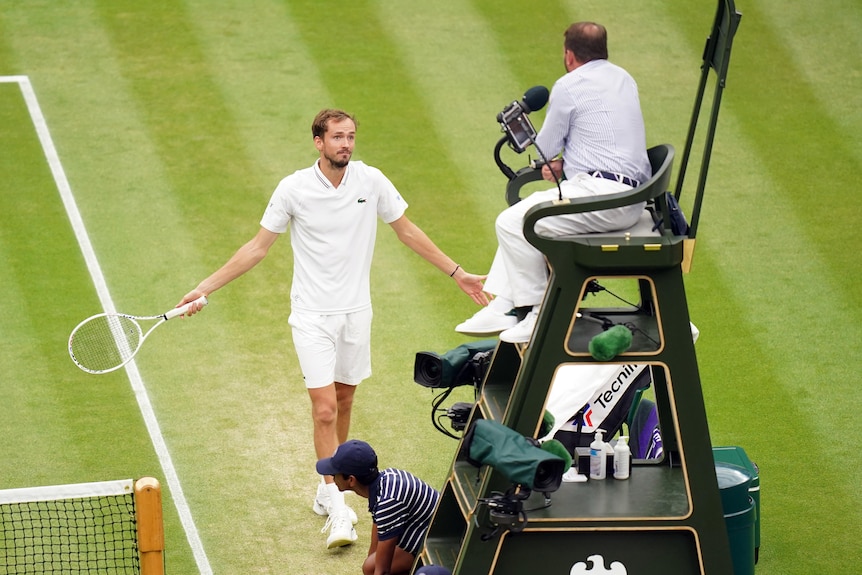 Daniil Medvedev with arms outstretched argues with the chair umpire at Wimbledon.
