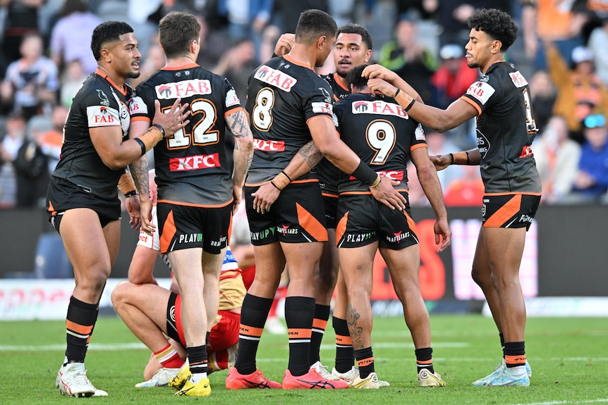 Wests Tigers NRL players celebrate defeating the Dolphins.